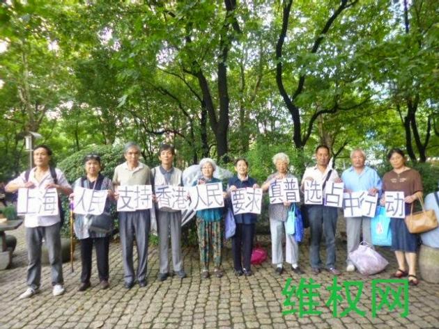 上海十數名市民在公園舉牌支持香港人佔中爭取真普選。(維權網)