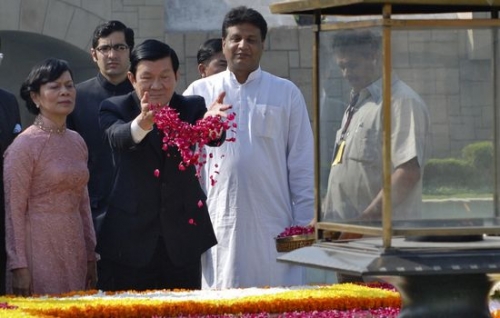 昨天，越南國家主席張晉創在與妻子（左）訪問位於新德里的甘地紀念館時捧起了玫瑰花瓣。