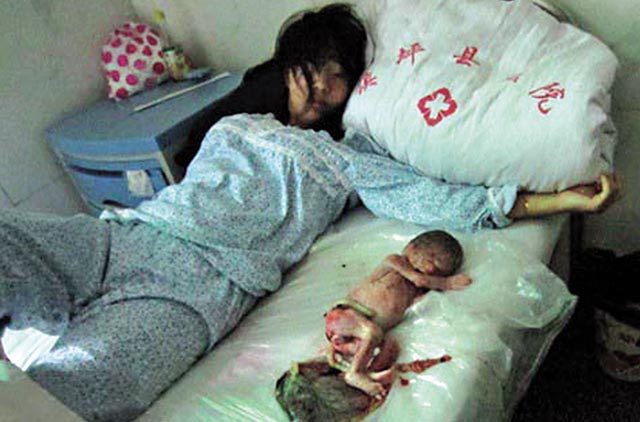 被強行墮胎的馮建梅，望着床上的嬰兒死胎，欲哭無淚。